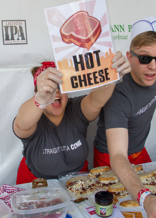 Jillian Wilber holds up the Hot Cheese sign to say that they have a sandwich ready, with her parmer Nicholas Wilber at the Last Grilled Cheese Invitational at the Los Angeles Center Studios on Saturday April 12, 2014.  