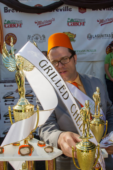 Tim Walker, the Chief Instigator and Founder, of the Grilled Cheese Invitational places the Grilled Cheese Champion sash on the trophy in preparation for the awards ceremony at the Last Grilled Cheese Invitational at the Los Angeles Center Studios on Saturday April 12, 2014.  